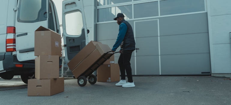 Déménagement Local - déménageurs locaux,déménageurs locaux Montréal,déménageurs locaux à Montréal,déménageurs Montréal locaux Un homme chargeant des cartons dans une camionnette.
