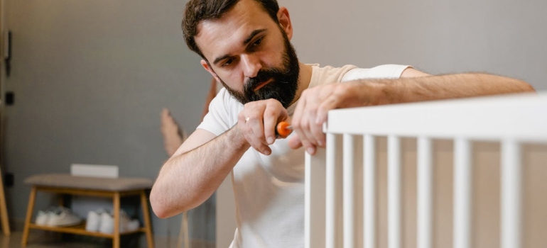 Un homme assemblant le berceau