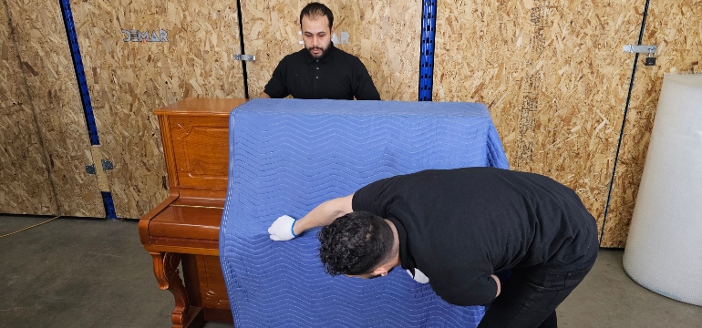 Service d'enlèvement et de livraison à Montréal emballant un piano