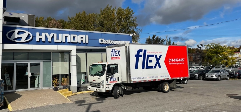 A truck from commercial movers Montreal in front of a store.